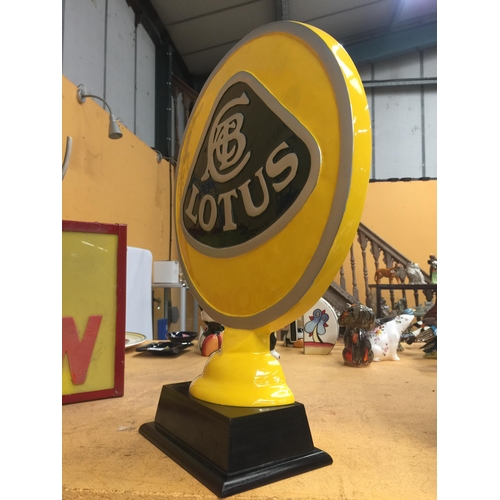 51 - A YELLOW METAL LOTUS SIGN ON WOODEN BASE