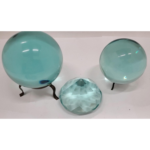 168 - TWO TURQUOISE GLASS 'CRYSTAL BALLS' ON STANDS, A LARGE TURQUOISE CRYSTAL PLUS TWO PAPERWEIGHTS