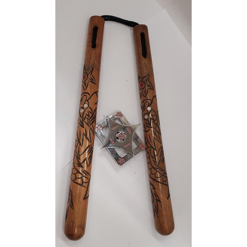 171 - A NINJA BELT BUCKLE AND A SET OF CARVED WOODEN NUNCHUCKS