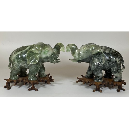 300 - A PAIR OF CHINESE JADEITE / JADE HARDSTONE ELEPHANT MODELS ON CARVED WOODEN STANDS, HEIGHT 16CM, LEN... 