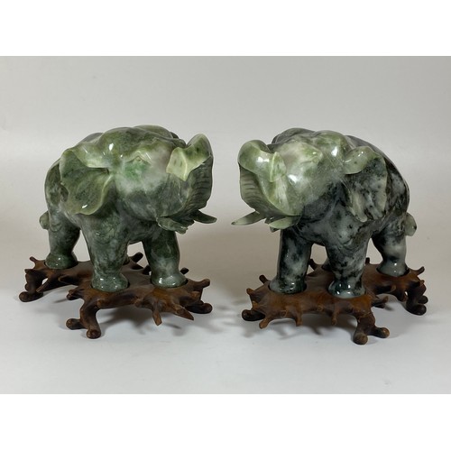 300 - A PAIR OF CHINESE JADEITE / JADE HARDSTONE ELEPHANT MODELS ON CARVED WOODEN STANDS, HEIGHT 16CM, LEN... 