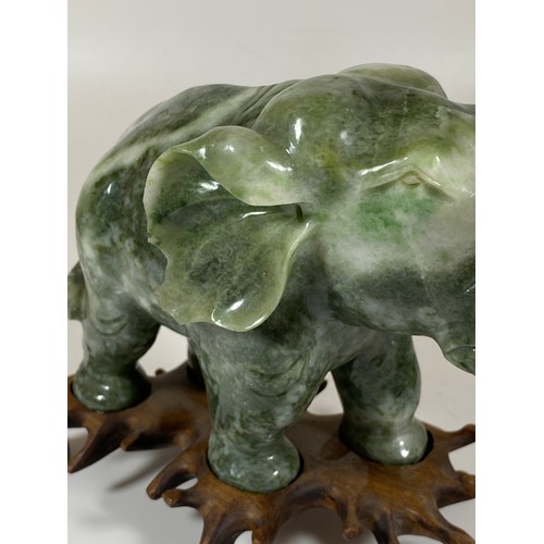 300 - A PAIR OF CHINESE JADEITE / JADE HARDSTONE ELEPHANT MODELS ON CARVED WOODEN STANDS, HEIGHT 16CM, LEN... 