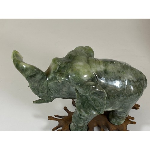 300 - A PAIR OF CHINESE JADEITE / JADE HARDSTONE ELEPHANT MODELS ON CARVED WOODEN STANDS, HEIGHT 16CM, LEN... 