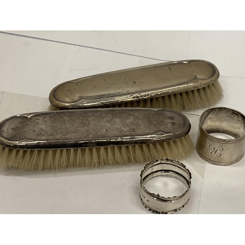 7 - FOUR HALLMARKED SILVER ITEMS - TWO BRUSHES AND TWO NAPKIN RINGS