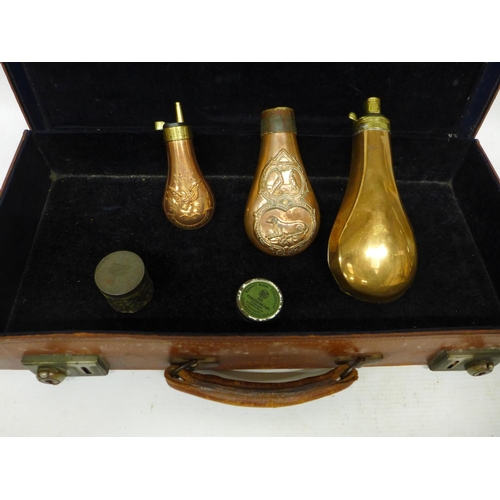 545 - THREE COPPER AND BRASS POWDER FLASKS, TWO CAP TINS AND A LEATHER CASE (A/F)