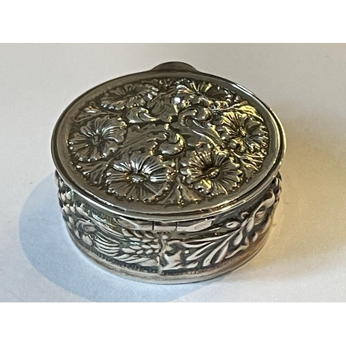 92 - A SILVER CIRCULAR PILL BOX WITH FLORAL DECORATION