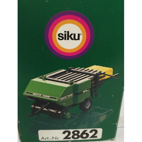 328 - TWO BOXED FARM MODELS, A SCHUCO FENDT TRACTOR, 1/43 SCALE AND A SIKU DEUTZ BALER, 1/32 SCALE