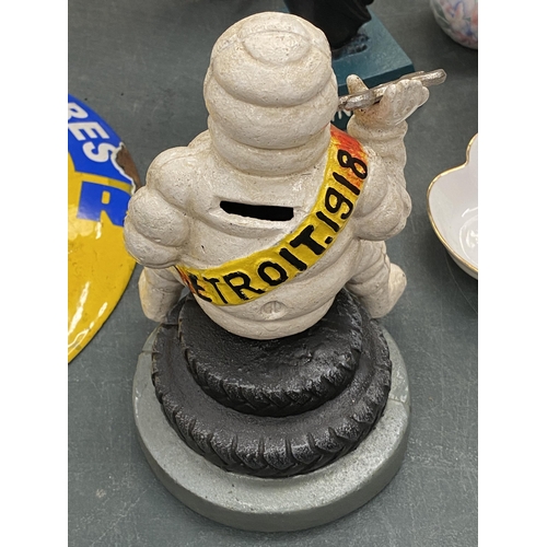 121 - A CAST MICHELIN MAN ON A TYRE MONEY BOX, HEIGHT 19CM