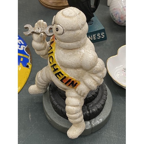 121 - A CAST MICHELIN MAN ON A TYRE MONEY BOX, HEIGHT 19CM