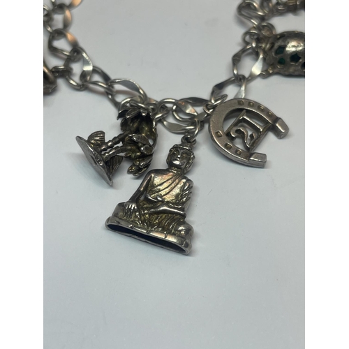 557 - A SILVER CHARM BRACELET WITH NINE VARIOUS CHARMS