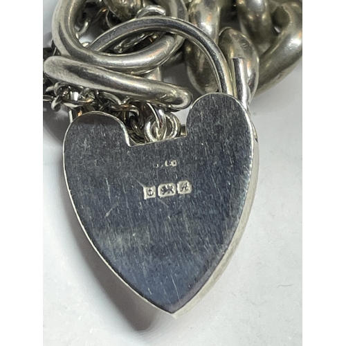 579 - A HEAVY SILVER WRIST CHAIN WITH HEART PADLOCK