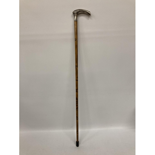 12 - A BELIEVED SILVER TOPPED WALKING STICK WITH FLORAL CHASED AND ENGRAVED DESIGN