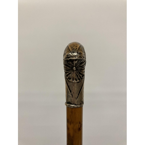 12 - A BELIEVED SILVER TOPPED WALKING STICK WITH FLORAL CHASED AND ENGRAVED DESIGN