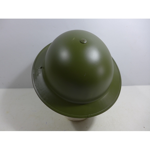 332 - A MID 20TH CENTURY GREEN PAINTED METAL BRITISH HELMET AND LINER