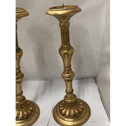 135 - A TALL PAIR OF CLASSICAL STYLE HEAVY WOODEN CANDLE STICKS WITH A GILT FINISH, HEIGHT 47CM