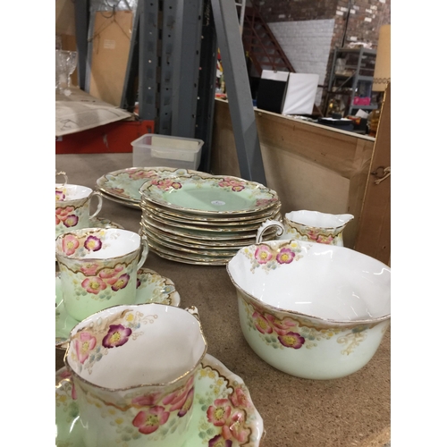 1054 - A VICTORIAN TEASET IN PALE GREEN WITH FLORAL PATTERN TO INCLUDE A CAKE PLATE, CUPS, SAUCERS, SIDE PL... 