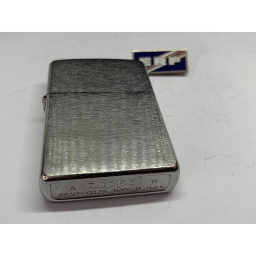 538 - A MADE IN USA ZIPPO LIGHTER AND AN ENAMEL ERF BADGE