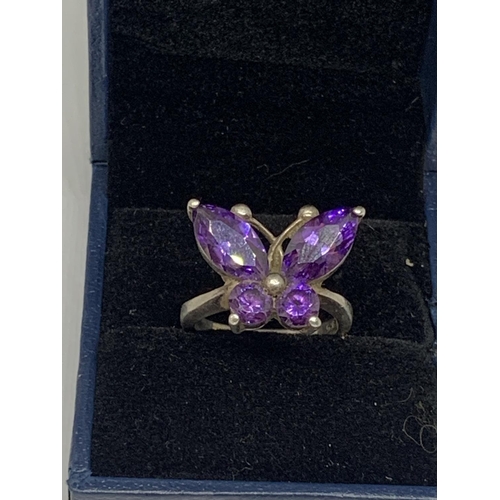 542 - A SILVER RING WITH PURPLE STONES IN A BUTTERFLY DESIGN SIZE M IN A PRESENTATION BOX