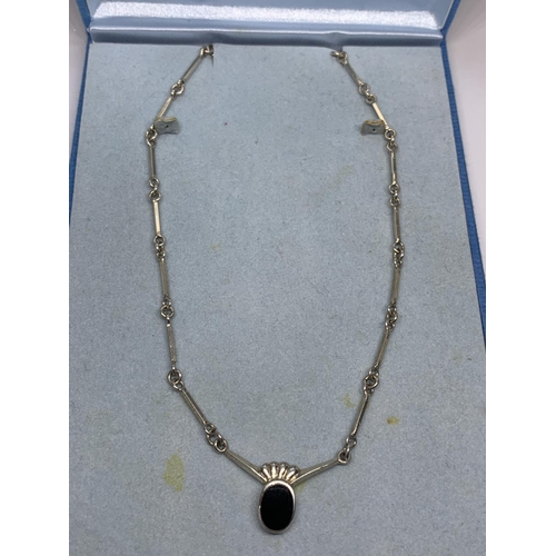 689 - A SILVER NECKLACE WITH A BLACK STONE IN A PRESENTATION BOX