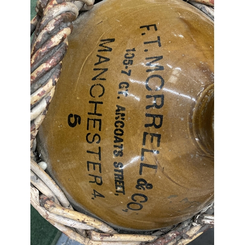 100 - A LARGE F T MORRELL & CO 105-107 GT ANCOATS STREET MANCHESTER STONEWARE VESSEL IN A WICKER BASKET