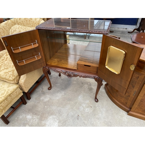 2583 - A WALNUT TWO DOOR COCKTAIL CABINET WITH CARVED RAIL, ON CABRIOLE LEGS, 35