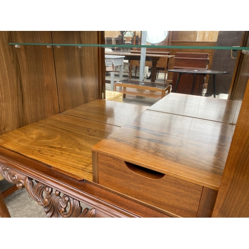 2583 - A WALNUT TWO DOOR COCKTAIL CABINET WITH CARVED RAIL, ON CABRIOLE LEGS, 35