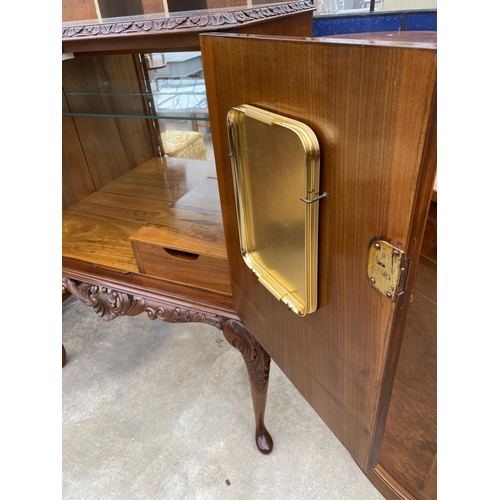 2583 - A WALNUT TWO DOOR COCKTAIL CABINET WITH CARVED RAIL, ON CABRIOLE LEGS, 35