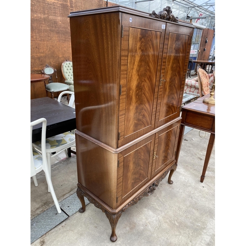 2592 - A MAHOGANY FOUR DOOR COCKTAIL CABINET WITH PULL-OUT SLIDE, ON CABRIOLE LEGS, 33.5