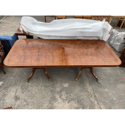 2580 - A REGENCY STYLE TWIN PEDESTAL WALNUT AND MAHOGANY CROSSBANDED DINING TABLE, THE PEDESTALS HAVING FOU... 