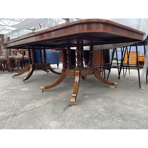 2580 - A REGENCY STYLE TWIN PEDESTAL WALNUT AND MAHOGANY CROSSBANDED DINING TABLE, THE PEDESTALS HAVING FOU... 