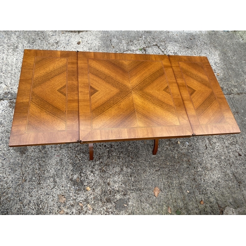 3078 - A MODERN SELVA MAHOGANY AND INLAID COFFEE TABLE WITH FOLD-OVER LEAVES ON X-FRAME BASE