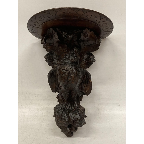 14 - A MID 19TH CENTURY HEAVILY CARVED BLACK FOREST WALL SCONCE