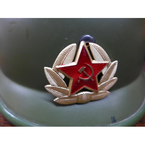 393 - A RUSSIAN TANK HELMET WITH LINER AND BADGE