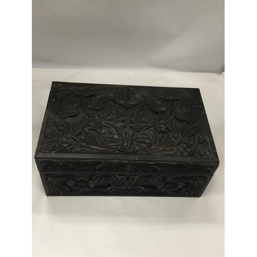 10 - A VINTAGE CARVED DARK OAK JEWELLERY BOX WITH INNER SECTION WITH INLAID COMPARTMENT LIDS