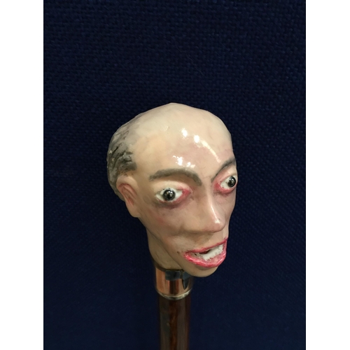 2 - A VINTAGE WOODEN WALKING STICK WITH PAINTED FIGURAL HEAD DESIGN, SIGNED WH, WITH COPPER FERRULE