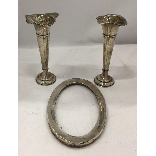 31 - THREE HALLMARKED SILVER ITEMS - PAIR OF WALKER AND HALL BUD VASES AND AN OVAL PHOTO FRAME