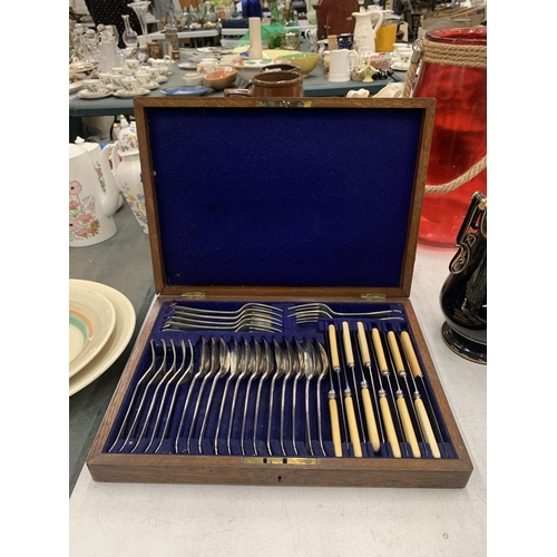 204 - A VINTAGE OAK CASED SILVER PLATED CUTLERY SET