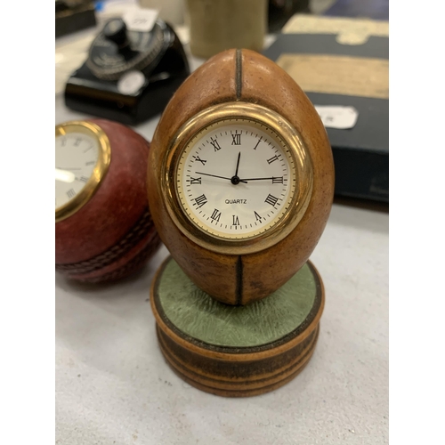 216 - TWO HISTORY CRAFT DESK CLOCKS IN THE FORM OF A CRICKET BALL AND RUGBY BALL