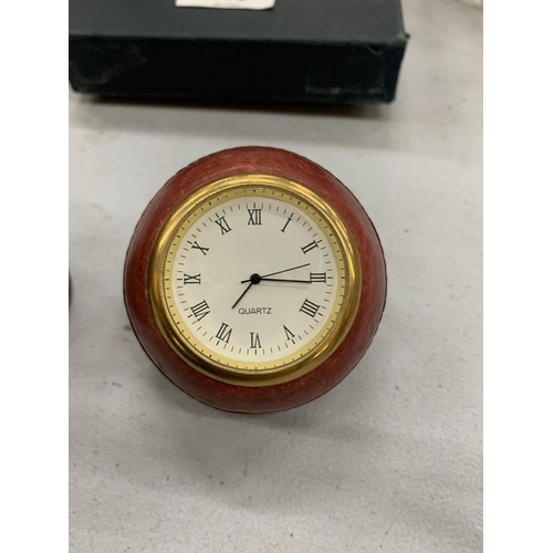 216 - TWO HISTORY CRAFT DESK CLOCKS IN THE FORM OF A CRICKET BALL AND RUGBY BALL