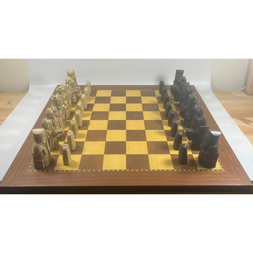 50 - A VINTAGE LEWIS CHESSMEN CHESS SET MODELLED AS MEDIEVAL FIGURES ON AN INLAID WOODEN BOARD, KING HEIG... 