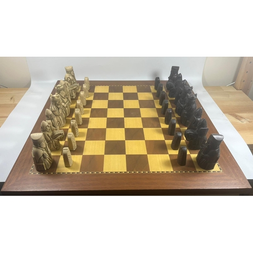 50 - A VINTAGE LEWIS CHESSMEN CHESS SET MODELLED AS MEDIEVAL FIGURES ON AN INLAID WOODEN BOARD, KING HEIG... 