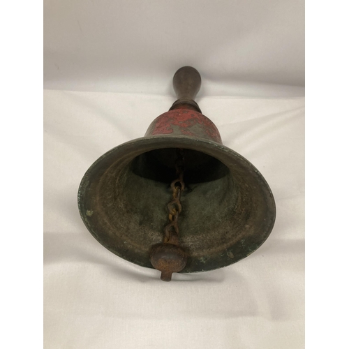 115 - A LARGE VINTAGE METAL BELL WITH A WOODEN HANDLE