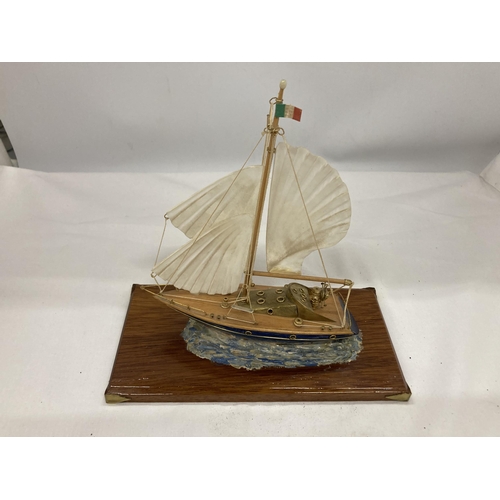 128 - A MODEL OF A VINTAGE ITALIAN YACHT, ON A WOODEN PLINTH, WITH ENAMEL AND BRASS HULL, HEIGHT APPROX 18... 