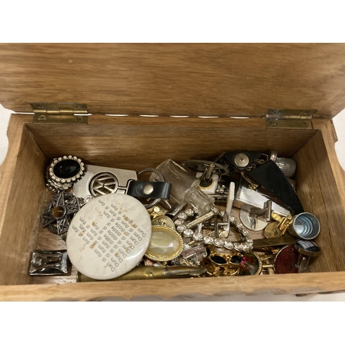 137 - A WOODEN BOX CONTAINING A QUANTITY OF COSTUME JEWELLERY TO INCLUDE BROOCHES, BADGES, CUFFLINKS, EARR... 