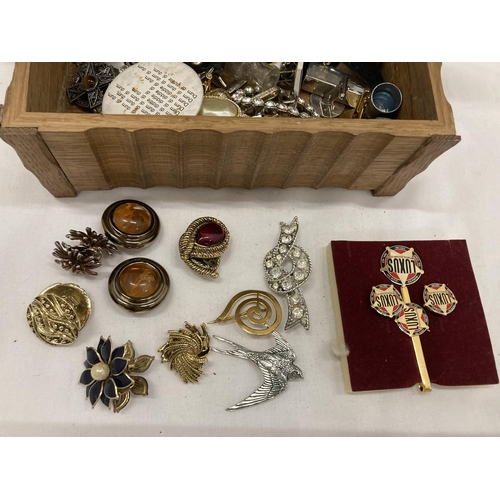 137 - A WOODEN BOX CONTAINING A QUANTITY OF COSTUME JEWELLERY TO INCLUDE BROOCHES, BADGES, CUFFLINKS, EARR... 