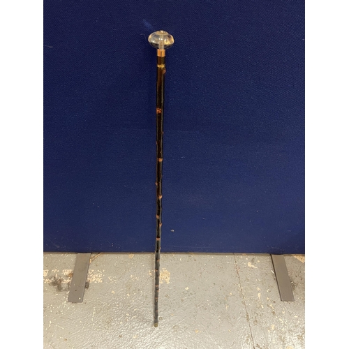 84 - A VINTAGE WALKING STICK WITH GLASS TOP AND METAL BANDING