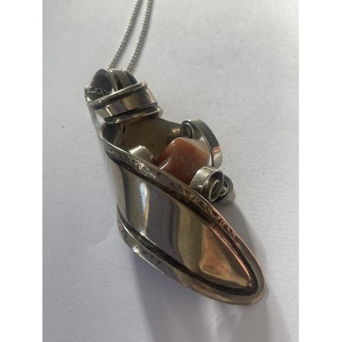 571 - AN ORNATE WHITE METAL SPOON AND AGATE PENDANT