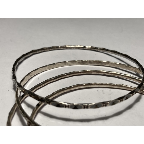 654 - FOUR SILVER BANGLES