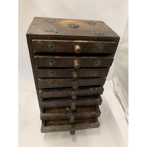 77 - A VINTAGE WOODEN TABLE TOP EIGHT DRAWER CABINET WITH METAL MOUNTS AND FITTINGS, 34 X 23 CM