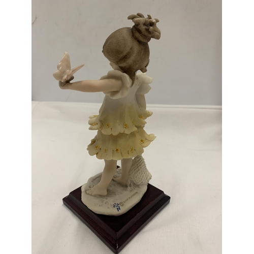 787A - A 1986 FLORENCE FIGURE OF A GIRL HOLDING A BUTTERFLY, SIGNED G.ARMANI